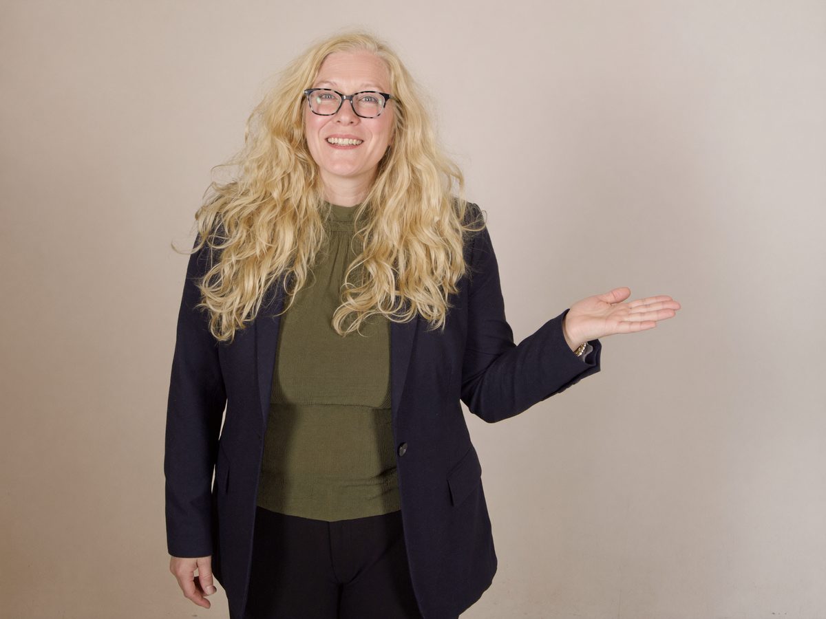 Hilary Jeffs standing with an open, welcoming gesture